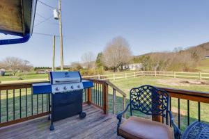 una parrilla en una terraza con una silla y un campo en Pet-Friendly Countryside Haven Near Cherokee Lake!, en Rogersville
