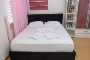 a bed with two white towels on top of it at ALBJONA GUESTHOUSE TIRANA in Tirana