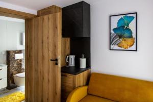 uma casa de banho com uma porta de madeira e uma cadeira amarela em NORDHOUSE II em Jastrzebia Gora