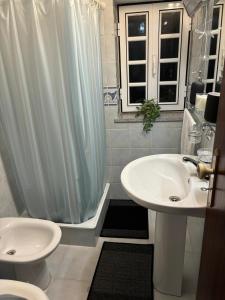 a white bathroom with a sink and a shower at White House in Piódão