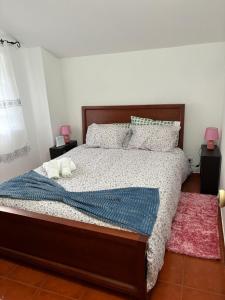 a bedroom with a bed with a blue comforter and pillows at White House in Piódão +21 photos