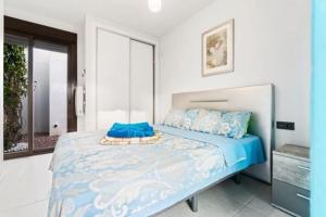 a bedroom with a bed with a blue comforter at VillaHeLena in Orihuela Costa +27 photos