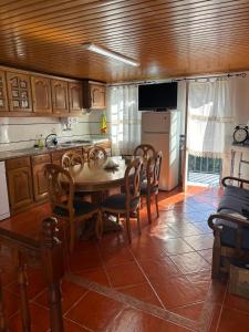 a kitchen with a table and chairs and a refrigerator at White House in Piódão