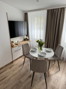 a dining room with a white table and chairs at Apartamenty Misdroy Parking Gratis 250 m od plaży in Międzyzdroje