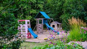 a playground with a slide and a play house at Clearwater Valley Resort in Clearwater