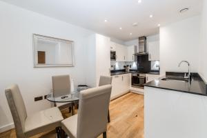 a kitchen with a table and a dining room at Apartments Near The O2 in London