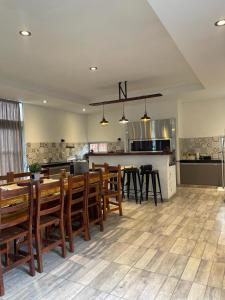 comedor y cocina con mesas y sillas de madera en Bitcoin s House Quinta Familiar 1000 m2 Piscina in 