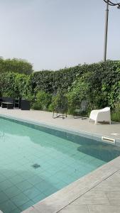 una piscina con 2 sillas y una mesa en Casa vacanza Hydrangea con piscina e giardino, en Bagni di Lucca