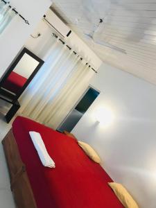 a bedroom with a red bed and a window at New hotel canel park in Polonnaruwa