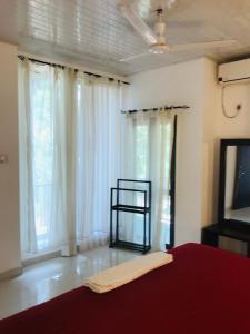 a bedroom with a bed and a tv and windows at New hotel canel park in Polonnaruwa
