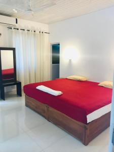 New hotel canel park في بولوناروا: غرفة نوم بسرير كبير مع بطانية حمراء