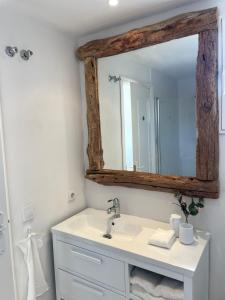 une salle de bain avec un lavabo et un miroir dans l'établissement ALOJAMIENTO ARENAL PARK, à Jávea