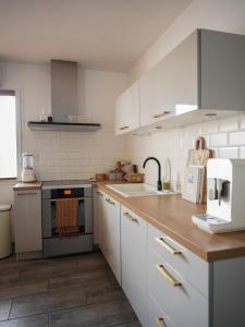 eine Küche mit weißen Schränken und einem Waschbecken in der Unterkunft CASA ALBA in Solliès-Pont