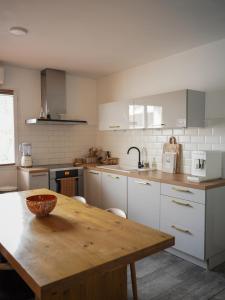 eine Küche mit einem Holztisch und weißen Schränken in der Unterkunft CASA ALBA in Solliès-Pont