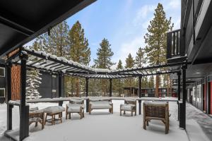 a covered patio with tables and chairs in the snow at Ambassador Lake Tahoe in South Lake Tahoe