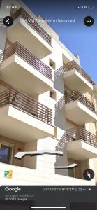 eine Ausstellung eines Gebäudes mit Balkonen auf einer Website in der Unterkunft Guillermo House Appartamento incantevole alta classe suite Attico in Alghero