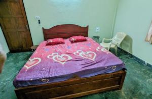 ein Bett mit einer lila Daunendecke mit Herz drauf in der Unterkunft Ushuaia- Entire villa, nestled in nature's embrace in Navelim