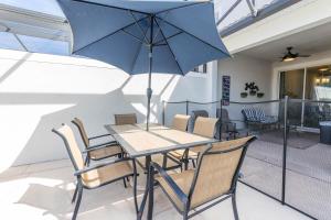 a table and chairs with a blue umbrella on a patio at MVP-4967WA SL townhouse in Kissimmee