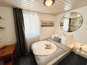 ein kleines Schlafzimmer mit einem Bett und einem Spiegel in der Unterkunft Sunny-Nest, Garden Apartment in Leukerbad