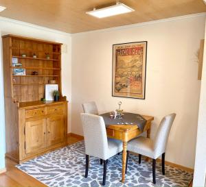 comedor con mesa de madera y sillas en Sunny-Nest, Garden Apartment en Leukerbad