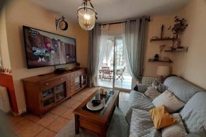 ein Wohnzimmer mit einem Sofa und einem TV in der Unterkunft El Paraíso de Mazarrón: playa y naturaleza in Puerto de Mazarrón