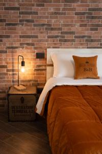 a bedroom with a bed and a brick wall at Principe Giardinelli in Piazza Armerina