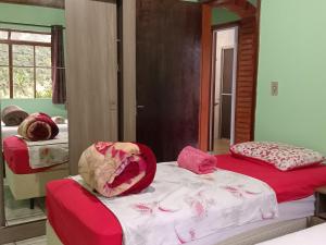 a bedroom with two beds and a mirror at Hospedaria das Azaleias in Novo Hamburgo