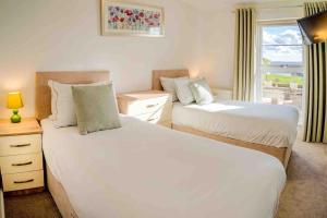 two beds in a room with a window at Ground Floor Sea View Apartment Private Terrace in Torquay