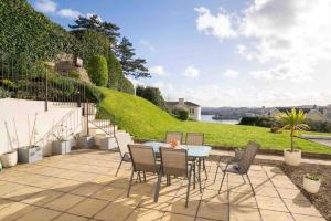 un patio con mesa, sillas y una colina en Ground Floor Sea View Apartment Private Terrace, en Torquay