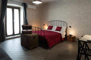 a bedroom with a bed with a red blanket and a window at Principe Giardinelli in Piazza Armerina