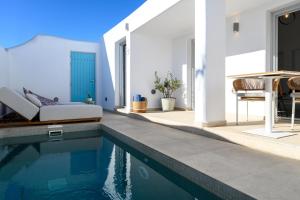 a villa with a swimming pool and a bedroom at Hypnōs boutique villa with amazing heated pool with jacuzzi in Fira