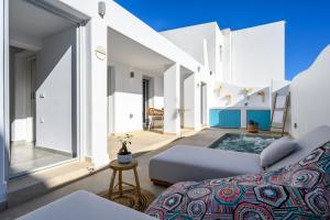 a living room with a couch and large windows at Hypnōs boutique villa with amazing heated pool with jacuzzi in Fira