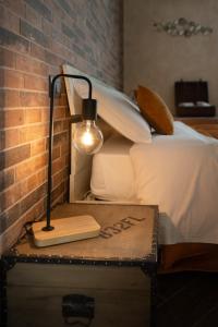 a lamp sitting on a chest next to a bed at Principe Giardinelli in Piazza Armerina