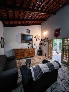 uma sala de estar com um sofá e uma televisão em Rancho Divino Espírito Santo- Beira Lago Corumbá IV em Alexânia