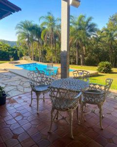 um pátio com uma mesa e cadeiras e uma piscina em Rancho Divino Espírito Santo- Beira Lago Corumbá IV em Alexânia