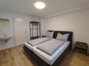 a bedroom with a large bed and a sink at FeWo Planer Altstadtwohnung mit Terrasse & Parkplatz in Memmingen