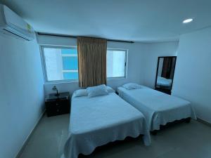 - 2 lits dans une chambre à la lumière bleue dans l'établissement Apartamento en Laguito Ed Torres del Lago 604 ICDI, à Carthagène des Indes