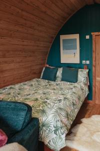 Cama en habitación con pared verde en Sea View Pod Close to Mountains / Snowdonia en Caernarfon