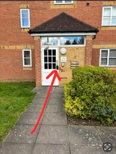 a red arrow on a sidewalk in front of a house at LONDON FRESHAir BREATHE APARTMENT in London