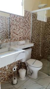 a bathroom with a toilet and a sink at Brotas Suítes Belo Quinto & Spazzio Bloco 2 in Brotas