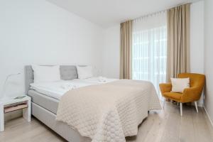 una camera bianca con un letto e una sedia di Dream Stay - 2 Porto Franco Apartments near Old Town a Tallinn