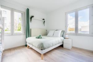 a white bedroom with a bed and two windows at ☆Luxury Disneyland -The Green-Wood - Paris ☆ in Lognes