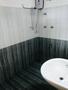 New hotel canel park في بولوناروا: حمام مع حوض ومغسلة بيضاء