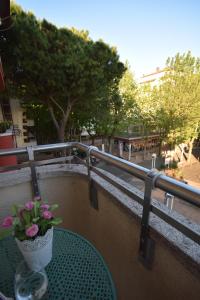 een tafel met een vaas met bloemen op een balkon bij Appartamento viale pedonale a due passi dal mare in Bellaria-Igea Marina