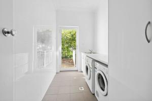 a white laundry room with a washer and dryer at Blue Vista in Leura