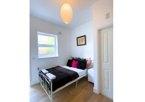 een kleine slaapkamer met een bed en een raam bij Cute Studio Garden Flat, 5 min to tube in Londen