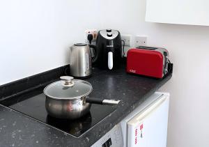 a stove top with a pot on top of it at Cute Studio Garden Flat, 5 min to tube in London