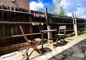 a table and two chairs next to a fence at Cute Studio Garden Flat, 5 min to tube in London