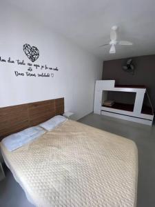 ein Schlafzimmer mit einem Bett und einem Schild an der Wand in der Unterkunft Duplic Guaruja Enseada Apartamento in Guarujá