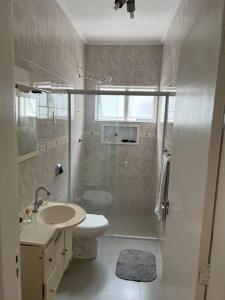 ein Bad mit einem WC, einem Waschbecken und einer Dusche in der Unterkunft Duplic Guaruja Enseada Apartamento in Guarujá